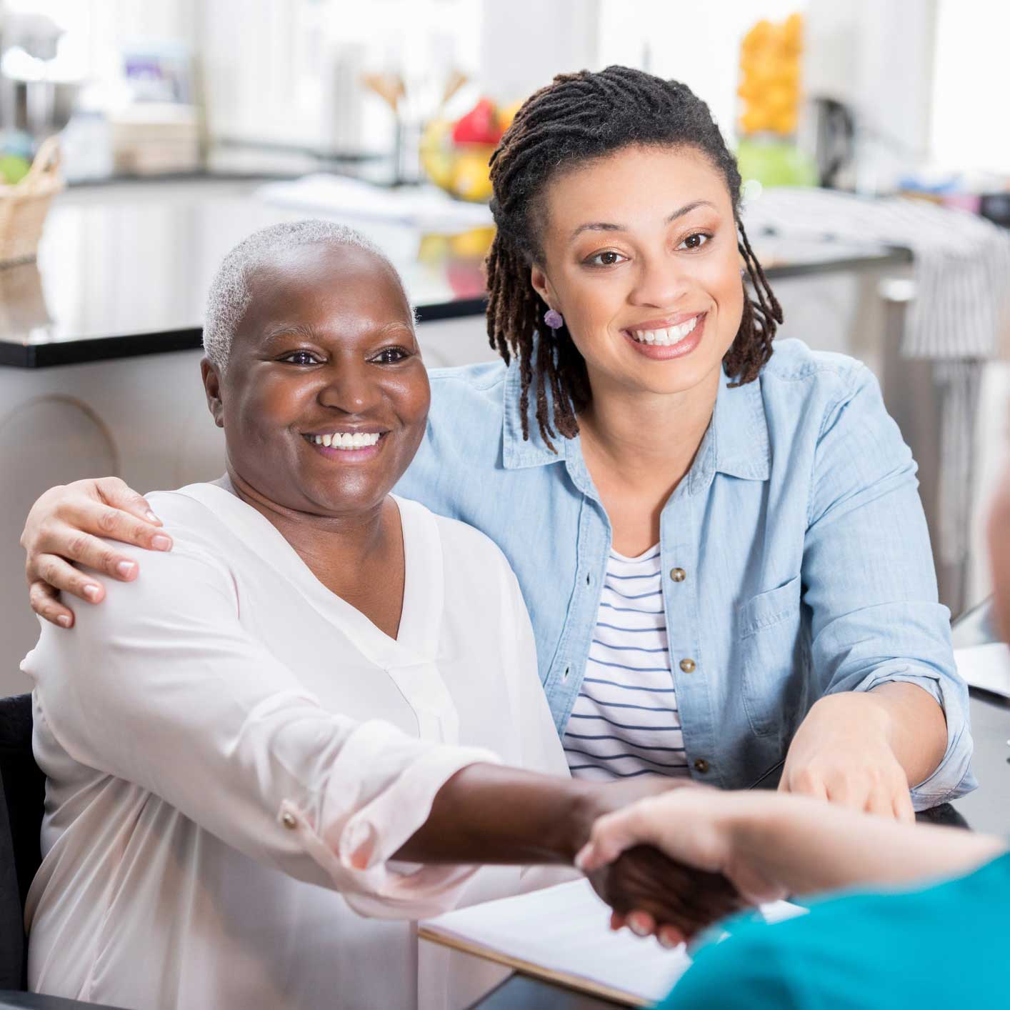 Mother and daughter smiling signing a contract