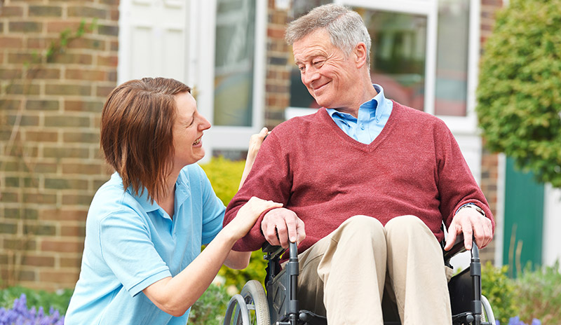 Caregiver with a senior man in a wheel chair